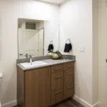 Bathroom with stacked laundry in the hallway of the 1 bed 1 bath floor plan