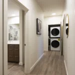Stacked laundry machines at the end of the hallway in the 2 bed 2 bath floor plan