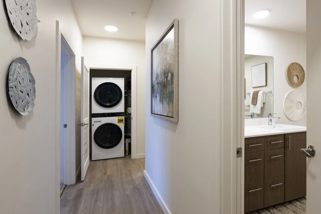 Stacked washer and dryer at the end of the hallway in the 3 bed 2 bath floor plan