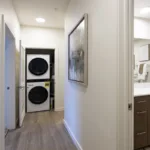 Stacked washer and dryer at the end of the hallway in the 3 bed 2 bath floor plan